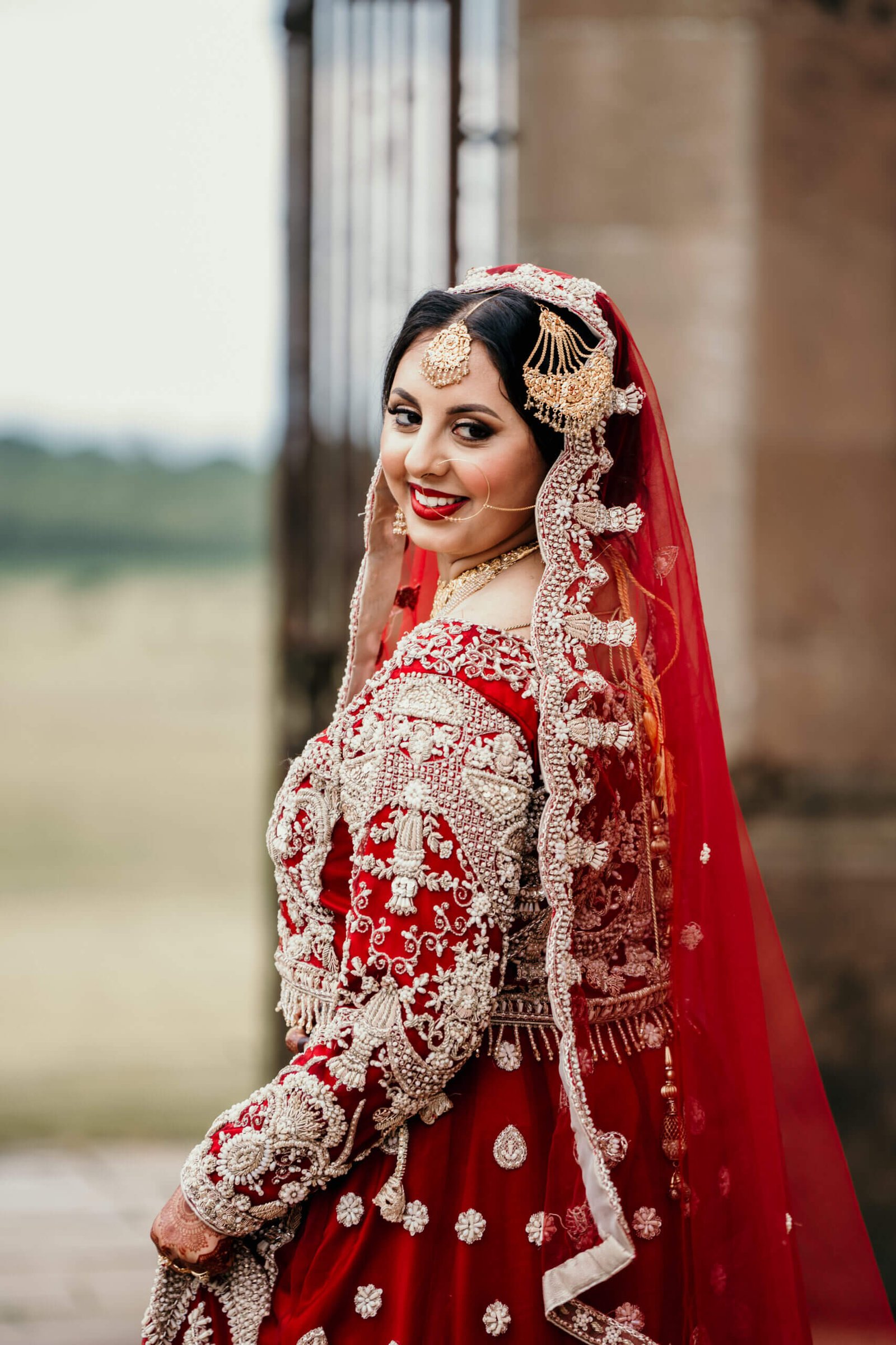 Asian Bride posing by gate at Kinmount House Annan